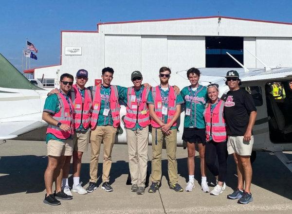 Aviation Student Organization showing young people standing in front of an airplane shed